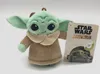 A plush toy of the character 'The Child' (Baby Yoda) from Star Wars: The Mandalorian, shown with its product tag. Produktbild-Vorschau