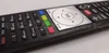 A close-up shot of a black remote control with silver accents and colored buttons. Podgląd zdjęcia produktu