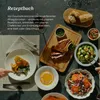 A table setting with various dishes and a cookbook. Produktbild-Vorschau