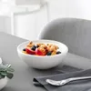 A white bowl of yogurt with fruit and granola sits on a gray table next to a gray napkin and spoon. Náhľad obrázku produktu