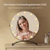 A woman is holding a cosmetic product in front of a lighted makeup mirror. Podgląd zdjęcia produktu