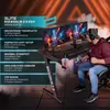 A person is sitting at a gaming desk with dual monitors, showcasing the desk's features. Produktbild-Vorschau
