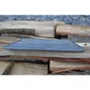 A cast iron grate rests on a pile of firewood. Voir les images du produit