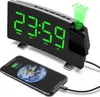 A digital alarm clock with a projected display and a smartphone charging. Produktbild-Vorschau
