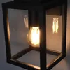 A close-up of a black outdoor lantern with a visible light bulb inside. Anteprima dell’immagine prodotto