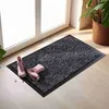 A doormat with pink boots on it, placed in front of a door. Voir les images du produit