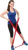 A woman is demonstrating an exercise using a red resistance band. Produktbild-Vorschau