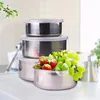 A stack of stainless steel food containers with clear lids, filled with strawberries and grapes. Produktbild-Vorschau
