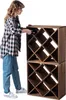 A person is placing a bottle into a wooden wine rack. Voir les images du produit