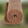 A rolled-up mat made of natural fibers, likely coconut coir, against a blurred green and gray background. Podgląd zdjęcia produktu