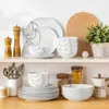 A collection of white porcelain dinnerware with a subtle line design, displayed on a white shelf with kitchen accessories. Náhled obrázku produktu