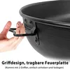 A close-up of a person's hand holding a handle of a black metal fire pit. Náhled obrázku produktu