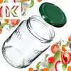 A glass jar and its lid are shown, surrounded by various fresh vegetables and herbs, with a logo in the upper left corner. Produktbild-Vorschau