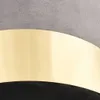A close-up shot of a section of a chair, showing the textured gray fabric, a curved gold band, and black material underneath.