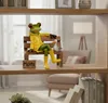 A decorative frog figurine sitting on a bench with a duck, placed on a wooden shelf. Produktbild-Vorschau
