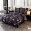 A bedroom scene with a bed made with black bedding featuring a white leaf pattern. Náhled obrázku produktu