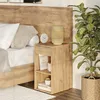A bedside table next to a bed, with a plant in a basket. Náhled obrázku produktu