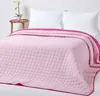 A pink quilted bedspread is laid out on a bed with white pillows. Produktbild-Vorschau