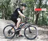 A man riding an electric bicycle on a dirt path in a forest. Produktbild-Vorschau
