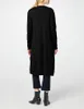 A woman is shown from behind wearing a long black cardigan and dark pants, with black boots. Produktbild-Vorschau