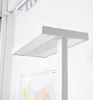 A close-up, low-angle shot of a modern white LED floor lamp with a map in the background. Produktbild-Vorschau