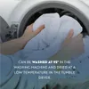 Hands placing white bedding into a washing machine. Produktbild-Vorschau