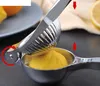 A close-up of a manual lemon squeezer with a lemon inside, demonstrating its use. Produktbild-Vorschau
