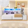 A modern white daybed with LED lighting, storage, and decorative pillows, set in a bedroom. Produktbild-Vorschau