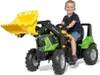 A young boy is riding a green toy tractor with a yellow front loader. Anteprima dell’immagine prodotto