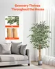 A living room scene with a couch and a large artificial ficus tree. Voir les images du produit