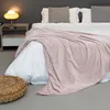 A cozy bedroom scene with a bed, blanket, and nightstand. Produktbild-Vorschau