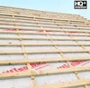 A close-up view of a roof under construction, showing wooden battens laid over a white underlayment membrane. Produktbild-Vorschau