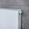 A close-up shot of a white radiator with a grey tiled wall in the background. Produktbild-Vorschau