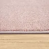 A close-up view of the edge of a pink rug on a wooden floor. Produktbild-Vorschau