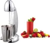 A chrome milkshake mixer with a stainless steel cup is shown next to a glass of red smoothie surrounded by fresh fruits. Produktbild-Vorschau