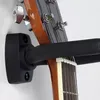 A close-up view of a guitar neck and headstock resting on a wall-mounted guitar hanger. Voir les images du produit