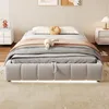 A bed with bedding and decorative pillows is shown in a room with a textured wall and bedside tables. Podgląd zdjęcia produktu