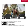 A Thomson TV with a family watching it, surrounded by Thomson accessories like a remote, streaming box, and game controller. Produktbild-Vorschau