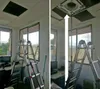 A room with a ceiling, windows, desks, and ladders, showing a ceiling vent being accessed. Anteprima dell’immagine prodotto
