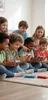 A group of children are sitting on the floor, playing a video game. Náhled obrázku produktu
