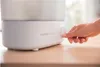 A hand is shown turning a dial on a white Philips Avent sterilizer. Produktbild-Vorschau