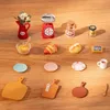 A collection of miniature kitchen items arranged on a wooden surface. Náhľad obrázku produktu