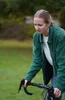 A woman is shown with a bicycle in an outdoor setting. Produktbild-Vorschau