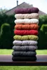 A stack of colorful cushions on a wooden table outdoors. Produktbild-Vorschau