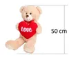 A teddy bear holding a red heart with the word "Love" on it, with a size indicator of 50 cm. Produktbild-Vorschau