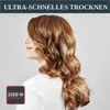 A woman with long, wavy brown hair is shown from the side, wearing a white shirt. The image has a dark blue banner at the top with text and a pink square in the bottom left corner with text and graphics. Anteprima dell’immagine prodotto