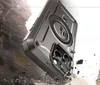 A rugged phone case is shown in a dramatic, rocky environment, with debris flying around it. Produktbild-Vorschau