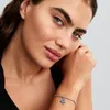 A woman wearing a bracelet with a charm. Anteprima dell’immagine prodotto