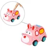 A pink toy ambulance with bunny ears is shown against a white background. A close-up inset shows a finger pressing down on the top of the toy. Produktbild-Vorschau