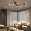 A modern living room with a track light fixture on the ceiling, a sofa, and a coffee table. Podgląd zdjęcia produktu